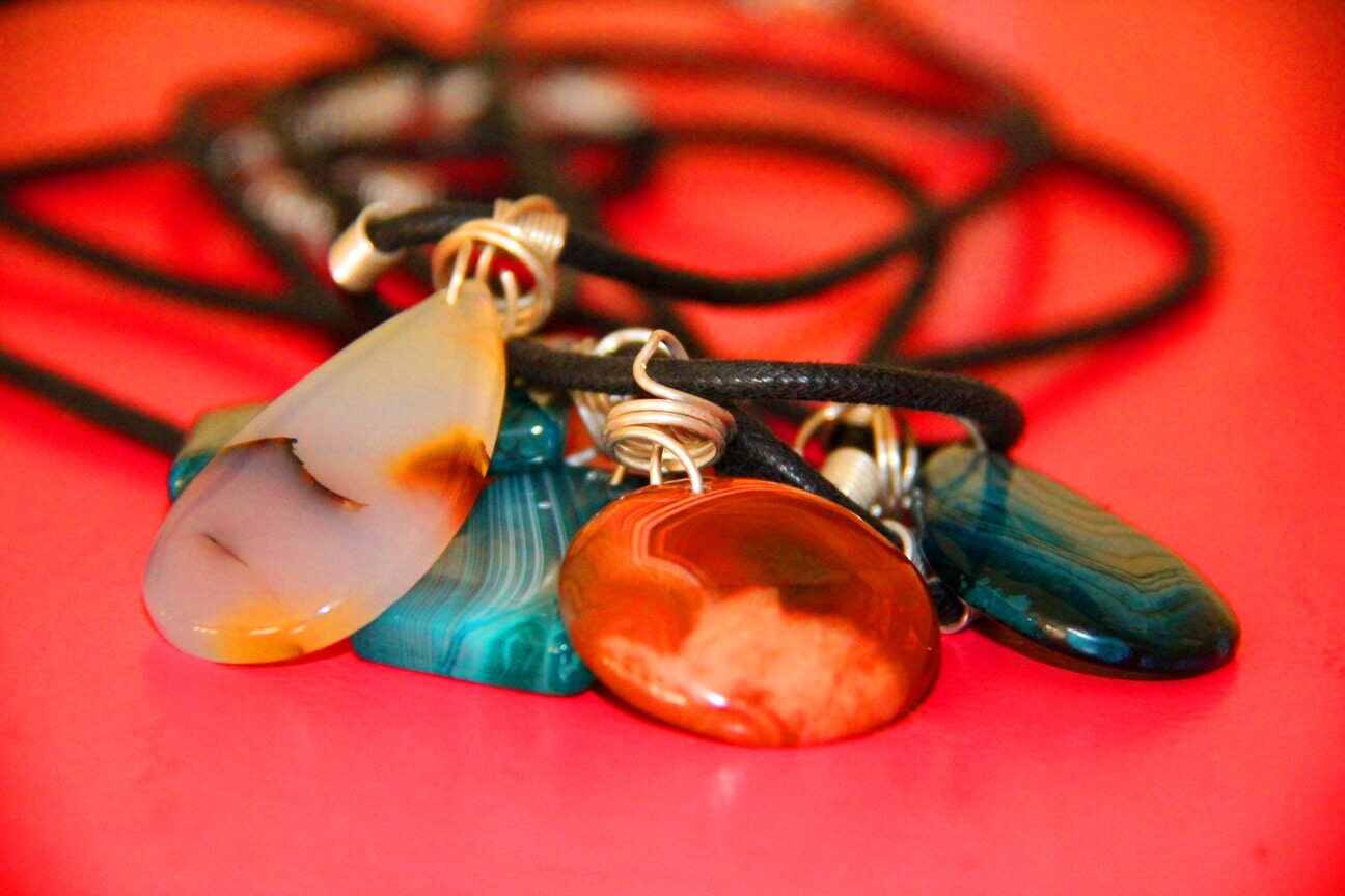 Colourful pendants on black cords on a red surface
